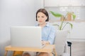 Portrait of woman in headphones working laptop computer home office on couch, in background is kitchen. Concept business Royalty Free Stock Photo