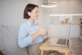 Portrait of woman in headphones working laptop computer home office on couch, in background is kitchen. Concept business Royalty Free Stock Photo