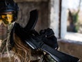 Portrait of a woman in a helmet and goggles with a machine gun in her hands. A female soldier in a camouflage uniform Royalty Free Stock Photo