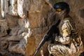 Portrait of a woman in a helmet and goggles with a machine gun in her hands. A female soldier in a camouflage uniform Royalty Free Stock Photo