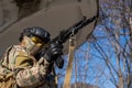 Portrait of a woman in a helmet and goggles with a machine gun in her hands. A female soldier in a camouflage uniform Royalty Free Stock Photo