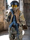 Portrait of a woman in a helmet and goggles with a machine gun in her hands. A female soldier in a camouflage uniform Royalty Free Stock Photo