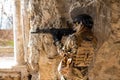 Portrait of a woman in a helmet and goggles with a machine gun in her hands. A female soldier in a camouflage uniform Royalty Free Stock Photo