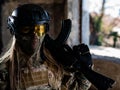 Portrait of a woman in a helmet and goggles with a machine gun in her hands. A female soldier in a camouflage uniform Royalty Free Stock Photo