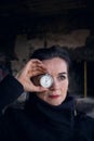 Portrait of woman in her 50s holding a pocket watch to her eyes Royalty Free Stock Photo