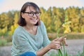 Portrait of 40s woman looking at camera with blooming flowers Royalty Free Stock Photo