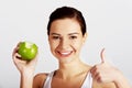 Portrait of woman holding apple showing thumb up Royalty Free Stock Photo