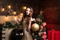 Portrait of woman holding big golden christmas bauble. Young woman with Christmas decoration. Santa girl celebrate Royalty Free Stock Photo