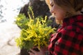 Portrait of a woman holding a bouquet of mimosa flowers. Royalty Free Stock Photo