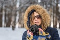 Portrait of a woman holding a digital camera in the woods in win Royalty Free Stock Photo