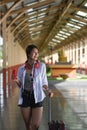 Woman holding her suitcase waiting for train on platform. Royalty Free Stock Photo