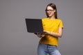 Portrait of a happy woman holding laptop and looking away solated over white background Royalty Free Stock Photo