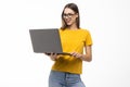 Portrait of a happy woman holding laptop and looking away solated over white background Royalty Free Stock Photo