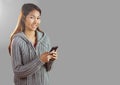 Portrait of woman holding phone with grey background Royalty Free Stock Photo