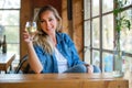 Portrait of a woman holding up a glass of craft cider beer at a nice restaurant, casual sunny weekend day