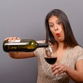 Portrait of woman holding wine bottle and glass against gray background Royalty Free Stock Photo