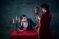 Portrait of woman in image of vampire looking in mirror to see her endless youth. Male looking at woman. Immortal family Royalty Free Stock Photo