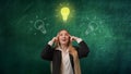 Portrait of a woman isolated on a green background, light bulbs are depicted on top. The girl is excited about the idea Royalty Free Stock Photo