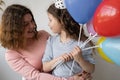 Portrait of a woman with a little girl kneeling on the birthday of a young lady.They are sitting on a chair. Theen are Royalty Free Stock Photo