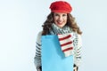 Smiling woman showing blue shopping bag with purchased sweater Royalty Free Stock Photo