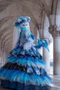 Portrait of woman looking back over her shoulder, under the arches at the Doges Palace, Venice, Italy during the carnival