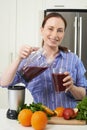 Portrait Of Woman Making Juice Or Smoothie In Kitchen Royalty Free Stock Photo