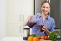 Portrait Of Woman Making Juice Or Smoothie In Kitchen Royalty Free Stock Photo