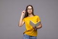 Portrait of a woman making notes in notepad and looking away at copy space isolated over white background Royalty Free Stock Photo