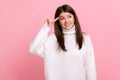 Portrait of woman making stupid sign with finger near head, gesturing bad mind, dumb insane idea.