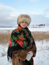 Portrait of the woman of middle age in a fur cap and a colorful shawl against the winter lake Royalty Free Stock Photo