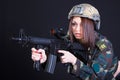 Portrait of a woman in a military uniform with an assault rifle