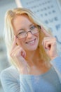 Portrait woman in opticians winking when trying on eyeglasses