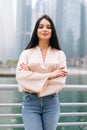 Portrait of business woman outdoors in the city streets in front of the group of skyscrapers and the river