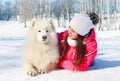 Portrait woman owner with white Samoyed dog lying on snow winter Royalty Free Stock Photo