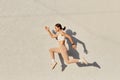 Portrait of woman with perfect body jumping over in the air, wearing white top and beige leggins, doing sports exercises outdoor, Royalty Free Stock Photo