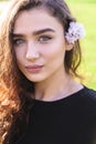 Portrait of woman with pink flower behind her ear