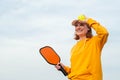 portrait woman player pickleball game over blue sky, pickleball yellow ball with paddle, outdoor sport leisure activity