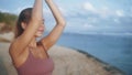 Portrait of woman practices yoga, concentrates on breathing at beach, slow motion