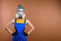 Portrait of a woman with a protective filtering mask. Builder woman in overalls and respirator posing in photo studio Royalty Free Stock Photo