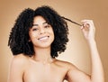 Portrait, woman and pull hair for curly beauty, natural growth and coil texture in studio on brown background. Happy