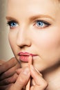 Portrait of a woman putting on lip liner. Royalty Free Stock Photo