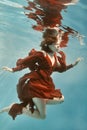 Portrait of a woman in a red dress floating underwater Royalty Free Stock Photo