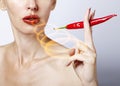 Portrait of the woman with red lips and red burning pepper Royalty Free Stock Photo