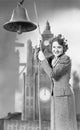 Portrait of woman ringing bell with model clock tower