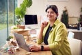 Portrait Of Woman Running Online Business Making Boutique Candles At Home Working On Laptop Royalty Free Stock Photo