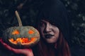 Portrait woman scary ghost in forest he has holding pumpkin