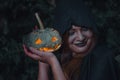 Portrait woman scary ghost in forest he has holding pumpkin