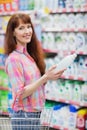 Portrait of woman with shopping basket holding detergent Royalty Free Stock Photo