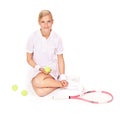 Portrait, woman and sitting with tennis balls, racket and skill for sports, competition and break in studio on white Royalty Free Stock Photo