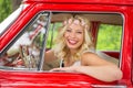 Portrait of woman sitting in vintage car and smiling